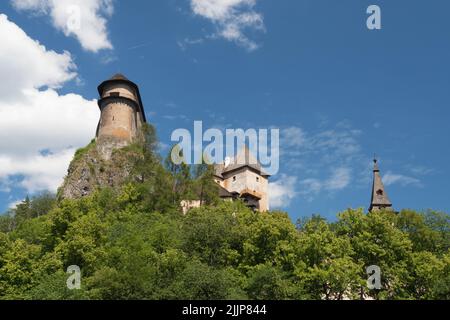 Vue sur les murs du château d'Orava. Nuages effilochés. Une colline surcultivée avec des arbres Banque D'Images