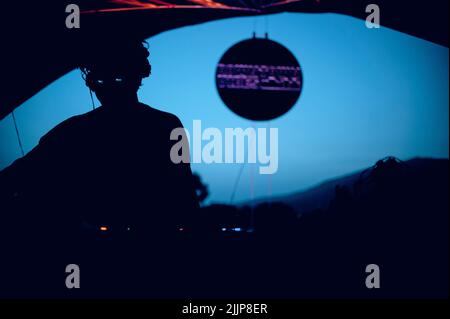 Un dj jouant un set à une fête dans un club sombre Banque D'Images