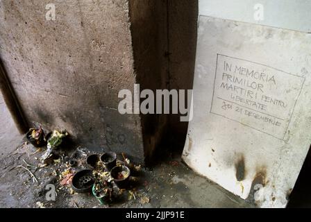 Bucarest, Roumanie, janvier 1990. Petit mémorial devant Sala Dalles pour les premières victimes de la révolution anticommuniste roumaine de décembre 1989. Sur le sol, les gens brûlent des bougies. Sur le mur il est écrit «en mémoire des premiers martyrs pour la liberté. Jeudi, 21 décembre. La mort des sept premières victimes du soulèvement a été causée par un camion de l'armée qui a frappé les manifestants. Banque D'Images