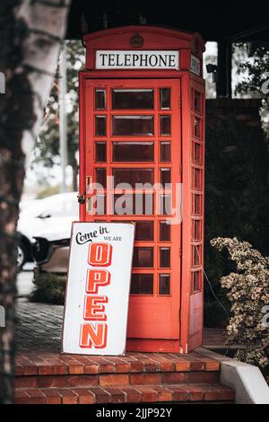 Une cabine téléphonique rouge avec enseigne ouverte à Tustin, États-Unis Banque D'Images