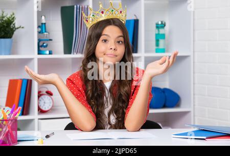 Visage amusant. Portrait d'une jeune fille ambitieuse avec couronne, sensation de princesse, confiance. Couronne de princesse d'enfant à la maison. Banque D'Images