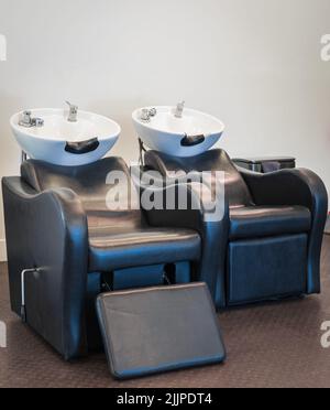 Salon de coiffure une rangée de lavabos et de chaises de lavage de cheveux. Chaises de lavage des cheveux fournisseurs salon de bassin shampooing coiffeur Banque D'Images