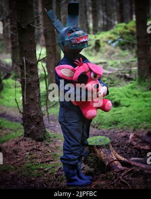 Un cliché vertical d'un homme portant un costume de lapin effrayant et tenant un lapin pirate dans sa main au milieu de la forêt Banque D'Images