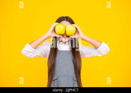 Fruits frais. Une adolescente tient des pommes sur fond de studio isolé jaune. Nutrition de l'enfant. Banque D'Images