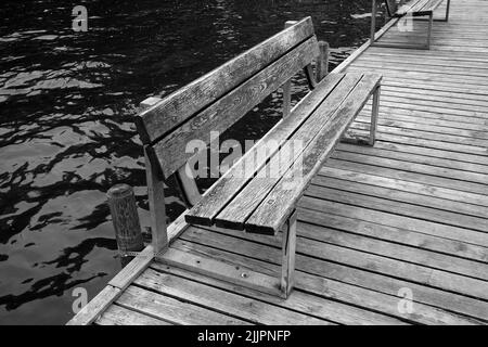 Un vieux banc en bois sur une plate-forme dans un lac Banque D'Images