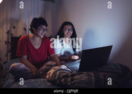 Deux jeunes femmes à un sleepover regardant des films Banque D'Images