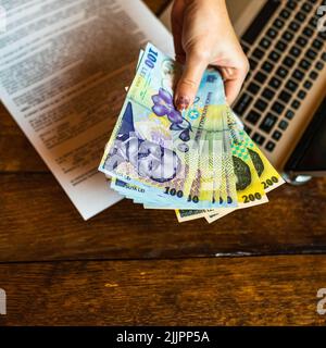 Un gros plan d'un contrat et de l'argent sur une main de homme Banque D'Images