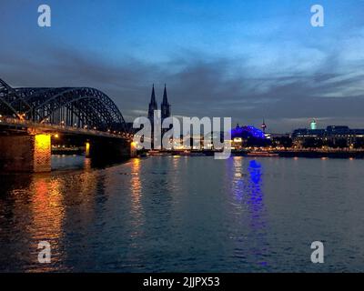 Une vue panoramique sur le paysage urbain de Cologne avec le pont Hohenzollern et la cathédrale de Cologne dans le fond du ciel bleu la nuit Banque D'Images