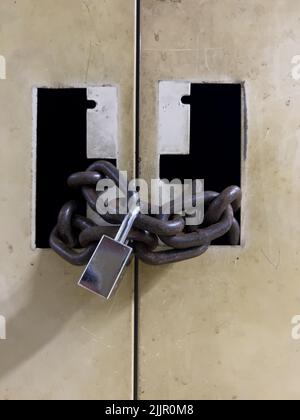 Un cadenas avec des chaînes sur une porte Banque D'Images