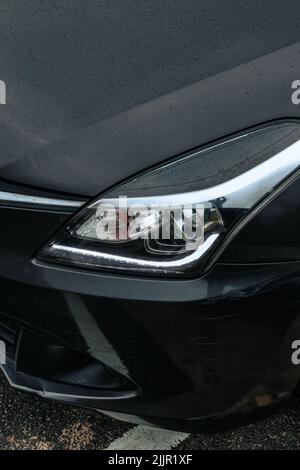 Un cliché vertical des gouttes d'eau sur une voiture noire Banque D'Images