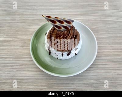 Pavlova, dessert à base de meringue, crème au chocolat et décoration au chocolat. Le gâteau porte le nom de la ballerine russe. Banque D'Images