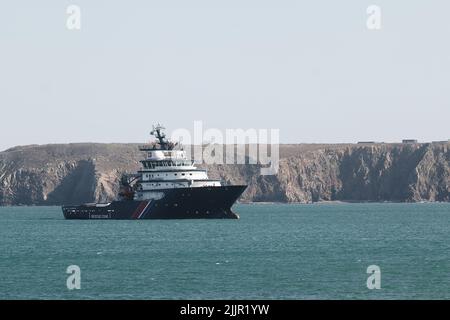 Un cargo en mer près d'une falaise abrupte par une journée ensoleillée. Image traitée avec VSCO avec A6 présélections Banque D'Images