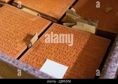 Buggingen, Allemagne. 25th juillet 2022. Des plaques de céramique avec des extraits de texte du roman "la découverte de la lenteur" se trouvent dans une boîte. Le céramiste de construction A. Benrath a transformé le célèbre roman de S. Nadolny « la découverte de la lenteur » en un monument en argile battue. Au cours de deux bonnes années de travail, Benrath a transmis l'histoire de l'explorateur polaire britannique J. Franklin (1786-1847), qui est mort au cours d'une expédition, sur des dalles d'argile dans son atelier de Buggingen. Credit: Philipp von Ditfurth/dpa/Alay Live News Banque D'Images