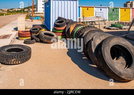Les rangées de pneus noirs et colorés penchent sur des chalets en bois à Majorque, Espagne Banque D'Images
