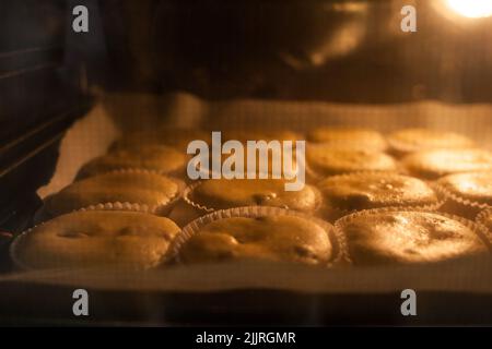 Étuis en papier remplis de pâte à muffins Banque D'Images