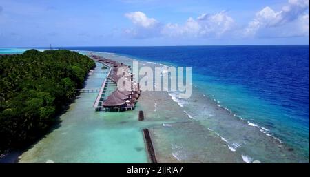 Une vue aérienne des hôtels sur la plage couverte de verdure sur une mer turquoise par un beau jour Banque D'Images
