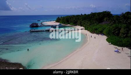 Une vue aérienne des hôtels sur une île couverte de verdure contre une mer turquoise par un beau jour Banque D'Images