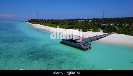 Une vue aérienne des hôtels sur une île couverte de verdure contre une mer turquoise par un beau jour Banque D'Images