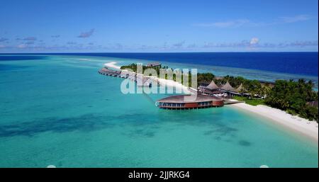 Une vue aérienne des hôtels sur une île couverte de verdure contre une mer turquoise par un beau jour Banque D'Images