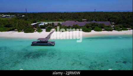 Une vue aérienne d'un complexe aux Maldives avec une plage de sable blanc et des arbres tropicaux Banque D'Images