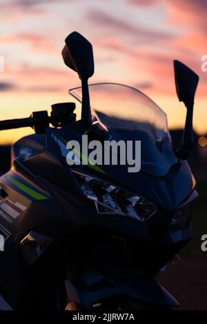 Une silhouette de la moto Ninja Kawisaki au coucher du soleil Banque D'Images