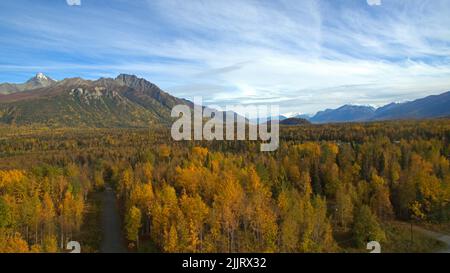 Une vue aérienne de la rivière Matanuska entourée d'arbres d'automne contre les montagnes à Palmer, en Alaska Banque D'Images