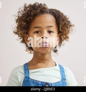 C'est mon visage de chiot-chien. Une adorable petite fille debout seul et tirant un visage drôle. Banque D'Images