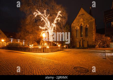 Grand arbre illuminé de lumières de Noël devant une église à Wernigerode Banque D'Images
