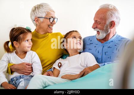 Heureux petits-enfants en visite chez le grand-père à l'hôpital. Concept de soutien, de famille et de soins de santé. Banque D'Images