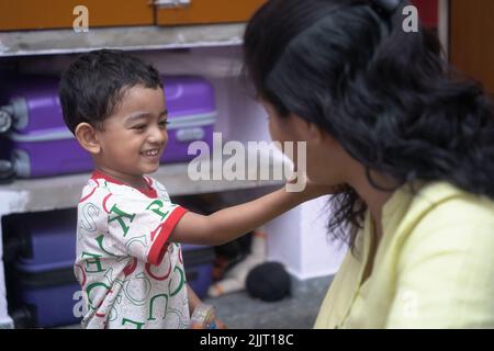 Une belle photo d'un petit enfant indien jouant avec sa mère Banque D'Images