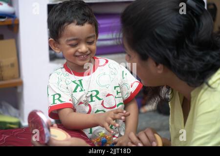 Une belle photo d'un petit enfant indien jouant avec sa mère Banque D'Images