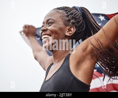 Je ne me suis jamais senti plus accompli. Une jeune athlète féminine tenant un drapeau. Banque D'Images
