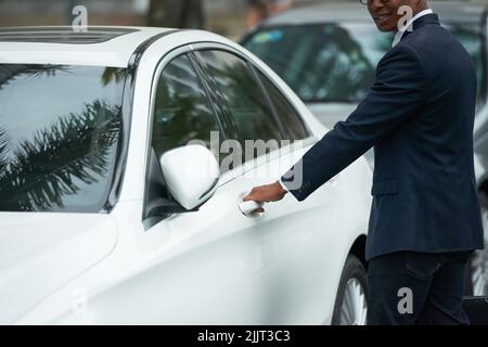 Image rognée d'un homme d'affaires souriant assis en voiture Banque D'Images