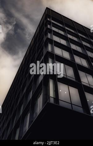 Photo d'un immeuble de bureaux moderne aux bords tranchants sous le ciel nuageux d'Irlande Banque D'Images