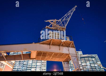 Vue de nuit de l'ancienne grue portuaire devant les bâtiments Banque D'Images