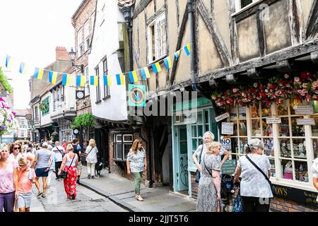 Ville de York la rue historique des ruines dans la ville, les touristes se mêlent parmi les boutiques pittoresques dans les rues étroites, York, North Yorkshire, Angleterre, Royaume-Uni Banque D'Images