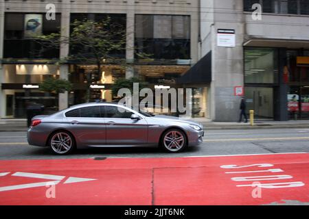 Une longue exposition d'une BMW 640 voiture grise dans la rue du centre-ville en plein jour à Vancouver, Cana Banque D'Images