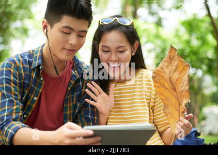 Jeune couple asiatique joyeux avec écouteurs pour le jeu vidéo Banque D'Images