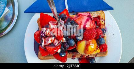 Une gaufre recouverte de crème glacée avec des baies et des fraises Banque D'Images