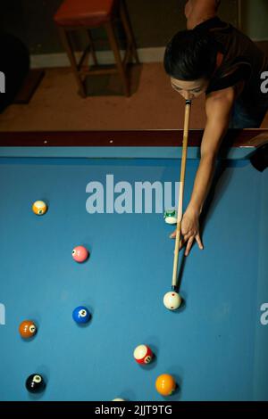 Joueur de billard qui frappe la balle de repère, vue d'en haut Banque D'Images