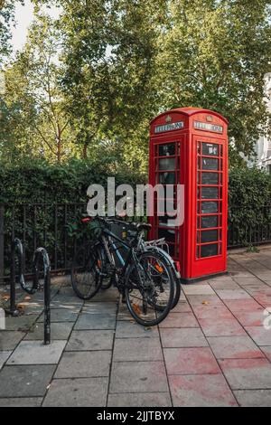 Un cliché vertical d'une cabine téléphonique rouge à Londres, au Royaume-Uni, sur une rue carrelée Banque D'Images