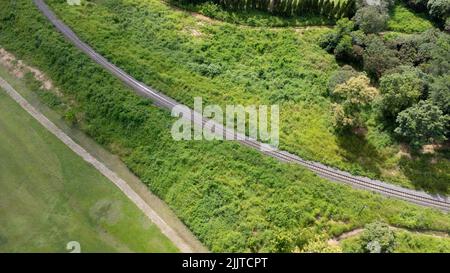 Vue aérienne d'un drone sur une voie ferrée dans un paysage rural avec forêt verte pendant la saison des pluies. Le drone a survolé la forêt et a vu le Banque D'Images