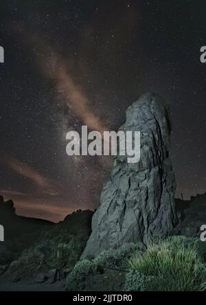 Une vue magnifique sur un immense rocher sous le ciel étoilé la nuit Banque D'Images