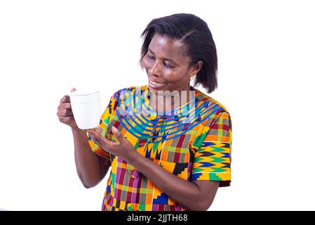 portrait d'une femme adulte debout et regardant une tasse de café à la main tout en souriant. Banque D'Images