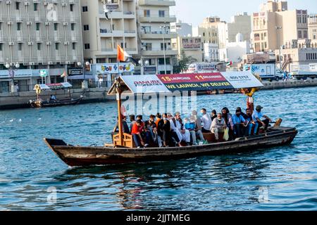 Beaucoup de touristes dans un bateau traversant la crique de Dubaï, eau Banque D'Images
