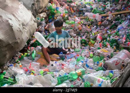 Les enfants qui travaillent passent par des bouteilles en polyéthylène téréphtalate (PET) dans une usine de recyclage à Dhaka, au Bangladesh, en 27 juillet 2022. Recyclage du plastique Banque D'Images