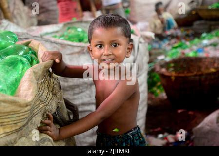 Les enfants qui travaillent passent par des bouteilles en polyéthylène téréphtalate (PET) dans une usine de recyclage à Dhaka, au Bangladesh, en 27 juillet 2022. Recyclage du plastique Banque D'Images