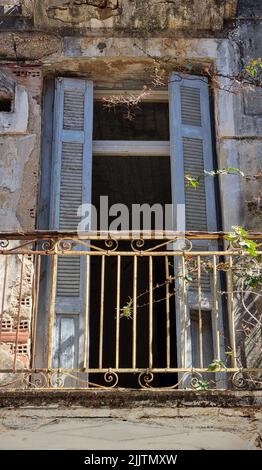 Un cliché vertical de la vieille maison aux intempéries en Grèce avec balcon rouillé Banque D'Images