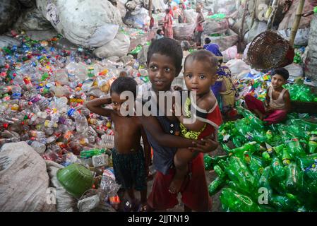 Les enfants qui travaillent passent par des bouteilles en polyéthylène téréphtalate (PET) dans une usine de recyclage à Dhaka, au Bangladesh, en 27 juillet 2022. Recyclage du plastique Banque D'Images