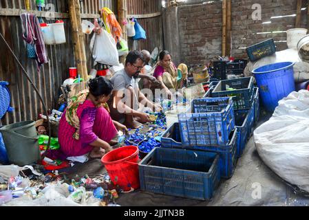 Les travailleurs trient les bouteilles en polyéthylène téréphtalate (PET) dans une usine de recyclage à Dhaka, au Bangladesh, en 27 juillet 2022. Bouteille de recyclage en plastique Banque D'Images